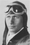 Black and white photo of a person wearing a pilot helmet and goggles, with a focused expression looking slightly to the side.