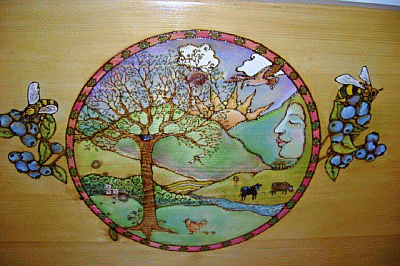 A colorful circular artwork depicts nature with a tree, animals, and a face merged into a landscape. Bees and berries border the sides.